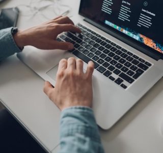 person wearing long-sleeve top working on laptop