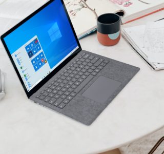 gray microsoft surface laptop computer on white table