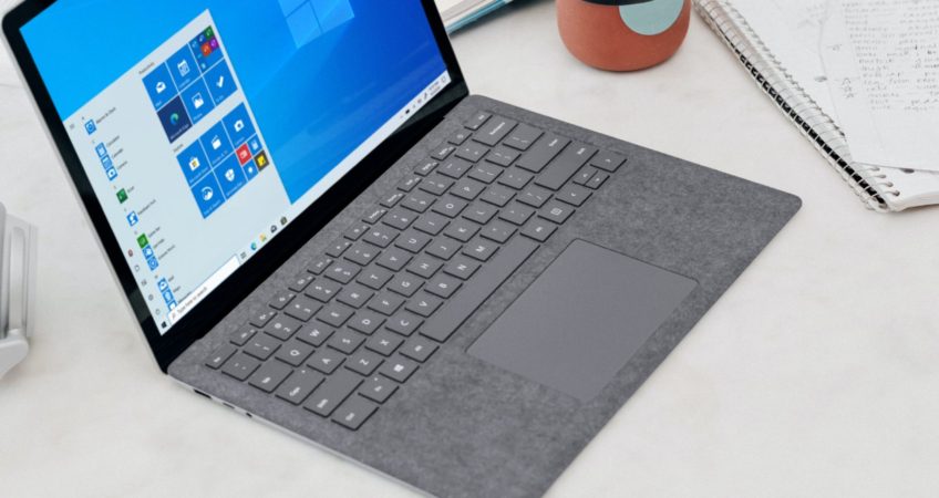 gray microsoft surface laptop computer on white table