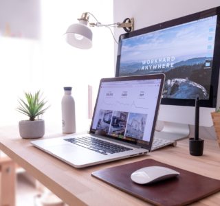 MacBook Pro on table beside white iMac and Magic Mouse