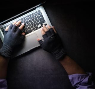 person in black long sleeve shirt using macbook pro