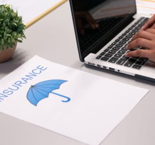 Free A Paper beside a Person Typing on a Laptop Stock Photo