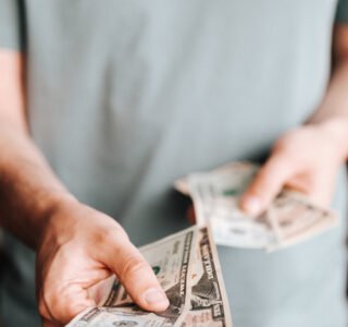 Free Crop man paying with American dollars Stock Photo