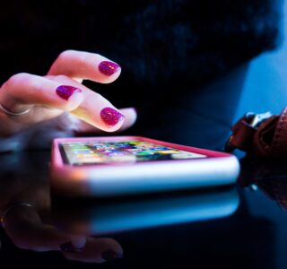 person using black smartphone with gray and pink case