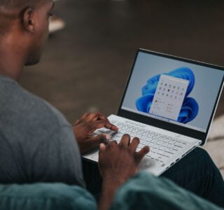 man in gray long sleeve shirt using Windows 11 computer