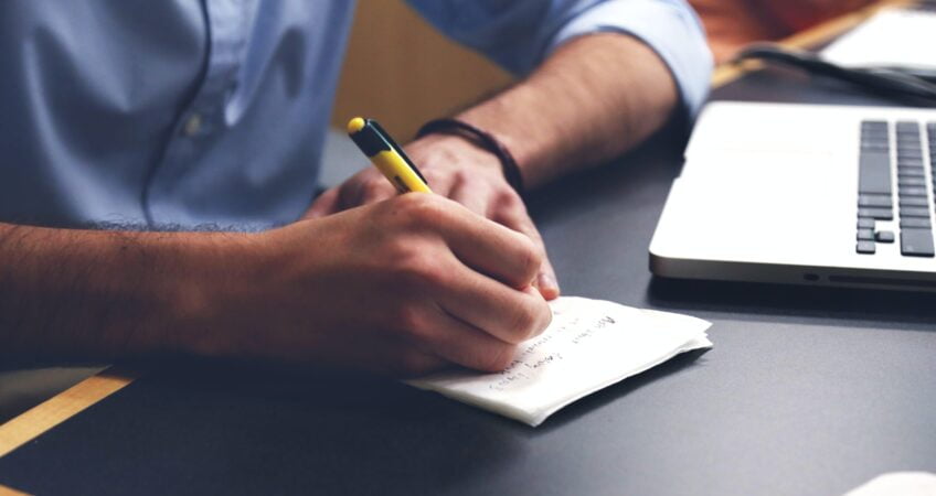 Free Person Writing on Paper Using Yellow and Black Pen Stock Photo