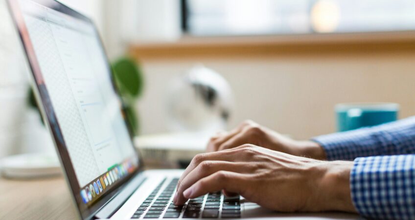 person typing on silver Macbook