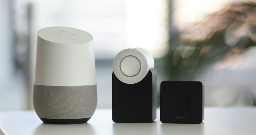 white and gray Google smart speaker and wo black speakers