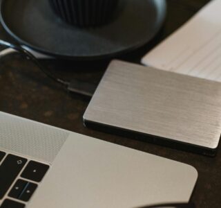 Free Closeup of an external hard drive connected to a laptop with a USB cable on a desk. Stock Photo