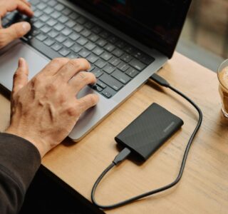 A man sitting at a table using a laptop computer