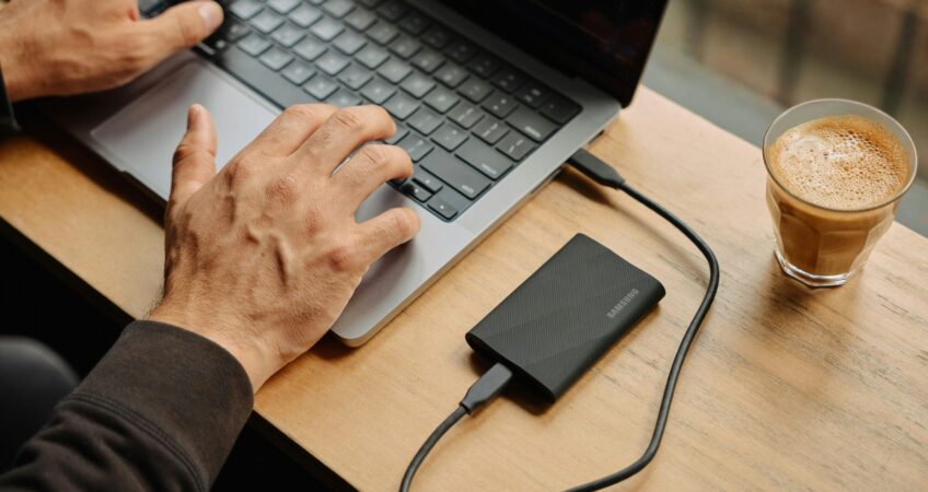 A man sitting at a table using a laptop computer