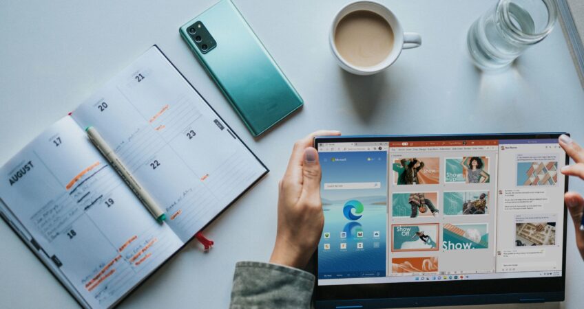 person using Windows 11 computer beside white ceramic mug on white table
