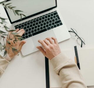 Free An overhead view of a person working on a laptop in a minimalist home office setting. Stock Photo