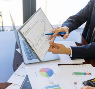 Free Business professionals discussing financial graphs and charts in an office setting. Stock Photo