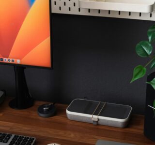 a desk with a laptop, keyboard, mouse and a monitor
