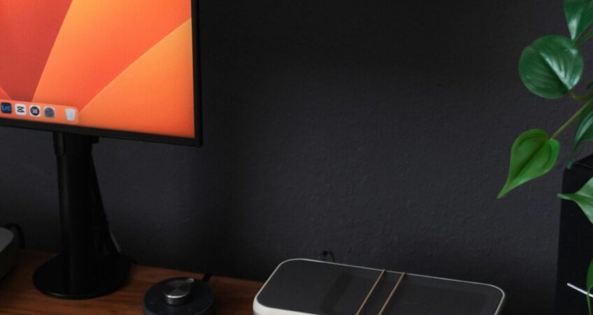 a desk with a laptop, keyboard, mouse and a monitor