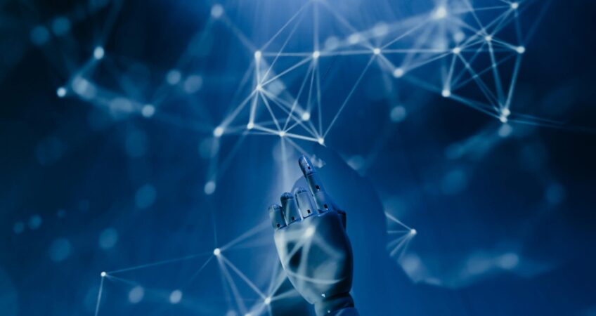 Free A robotic hand reaching into a digital network on a blue background, symbolizing AI technology. Stock Photo