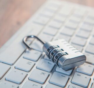 A combination lock rests on a computer keyboard.