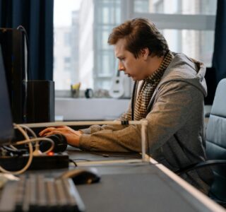 Free A concentrated professional working at a computer in a modern office setting. Stock Photo