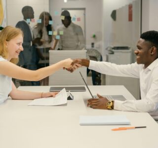 Free Business professionals completing a successful deal with a handshake in a modern office setting. Stock Photo