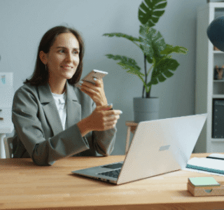 lady holding phone while working on a laptop